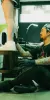 Experienced traditional Japanese tattoo artist Daisuke Sakaguchi prioritizes anatomical harmony, sitting at floor level to meticulously assess the flow of a bespoke Irezumi piece on a client's leg.