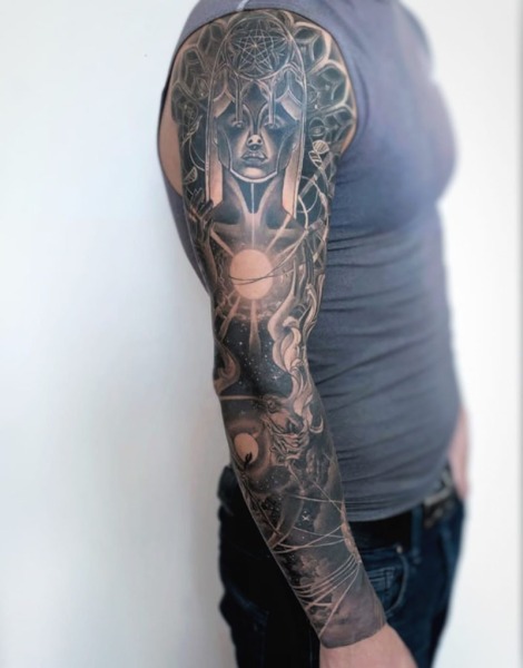 A journey through the stars: This custom full-sleeve project by Lubava blends intricate architectural portraiture with celestial space elements and sacred geometry for a flawless anatomical flow.