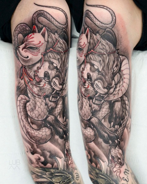Mythological Fury: This custom Neo-Japanese piece by Lubava combines the mystery of the Kitsune spirit with the power of a panther and snake, executed with sharp illustrative contrast.