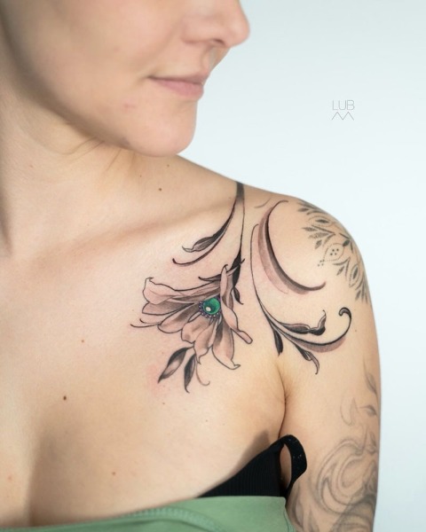 Jewelry in ink: This bespoke ornamental flower with a realistic emerald center by Lubava is designed to follow the natural elegance of the collarbone and shoulder.
