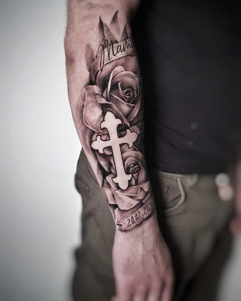 Black and grey realistic cross and roses memorial tattoo at Silent Moon, our private tattoo studio in Bermondsey, South East London.